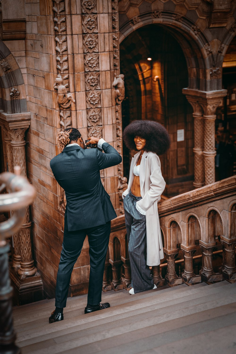 a man taking a picture of a woman in front of a building