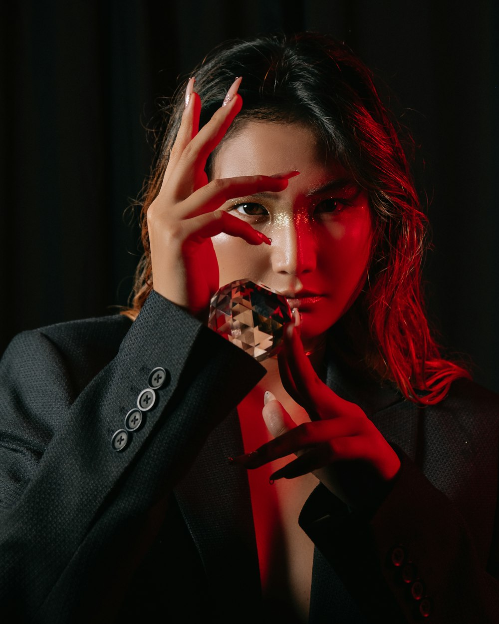 a woman with red makeup holding a crystal ball