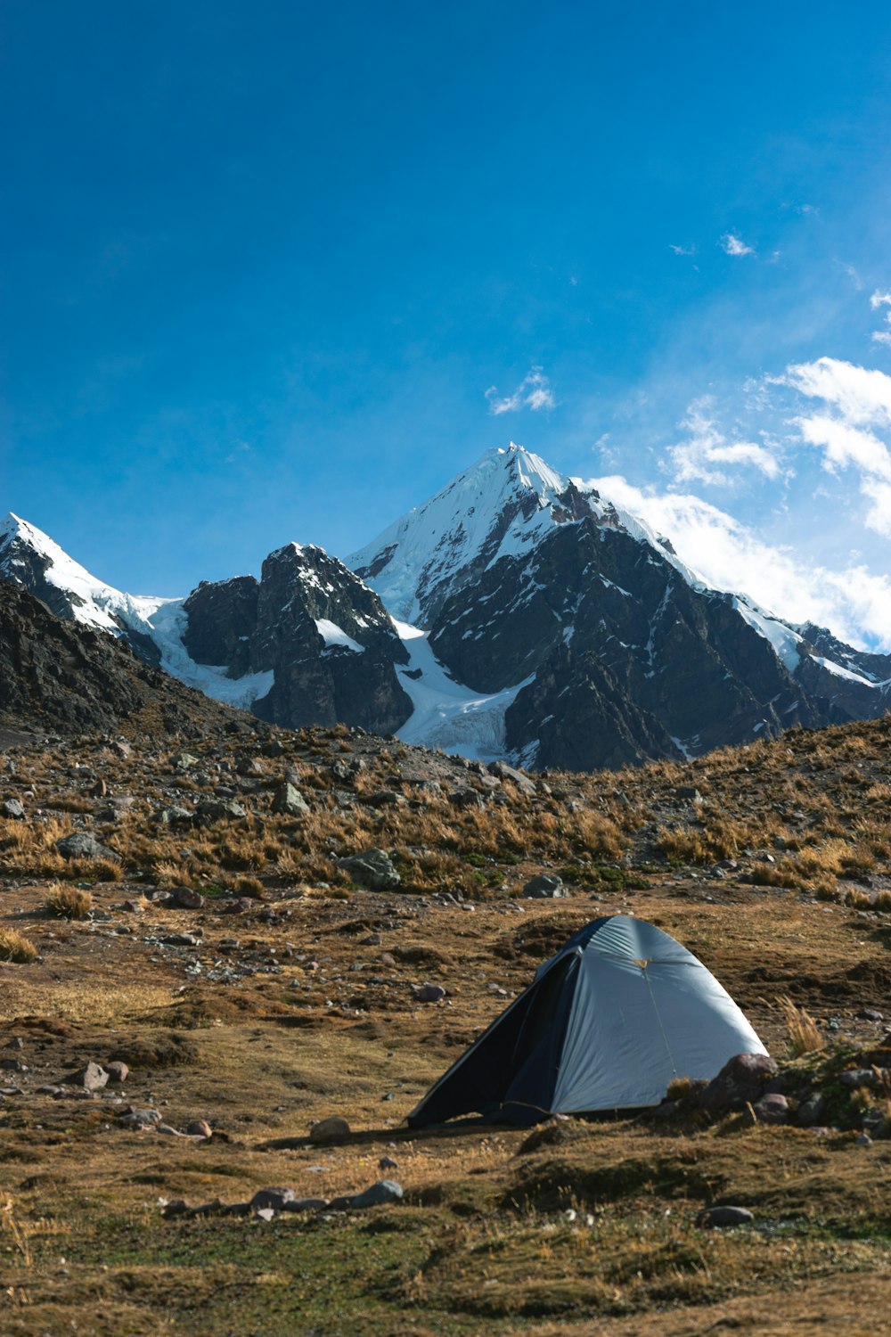 Una tenda piantata in un campo con le montagne sullo sfondo