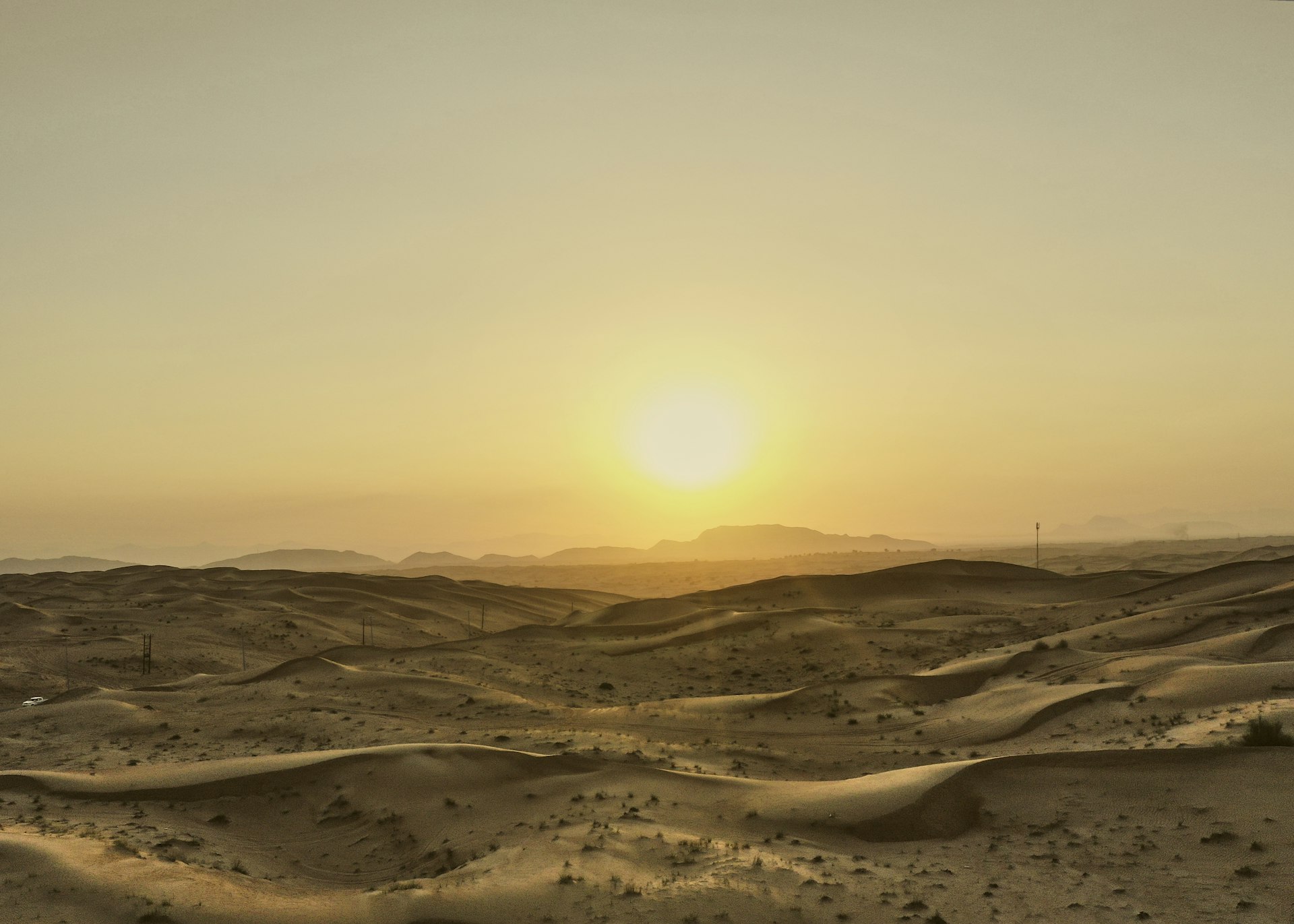 the sun is setting over a desert landscape