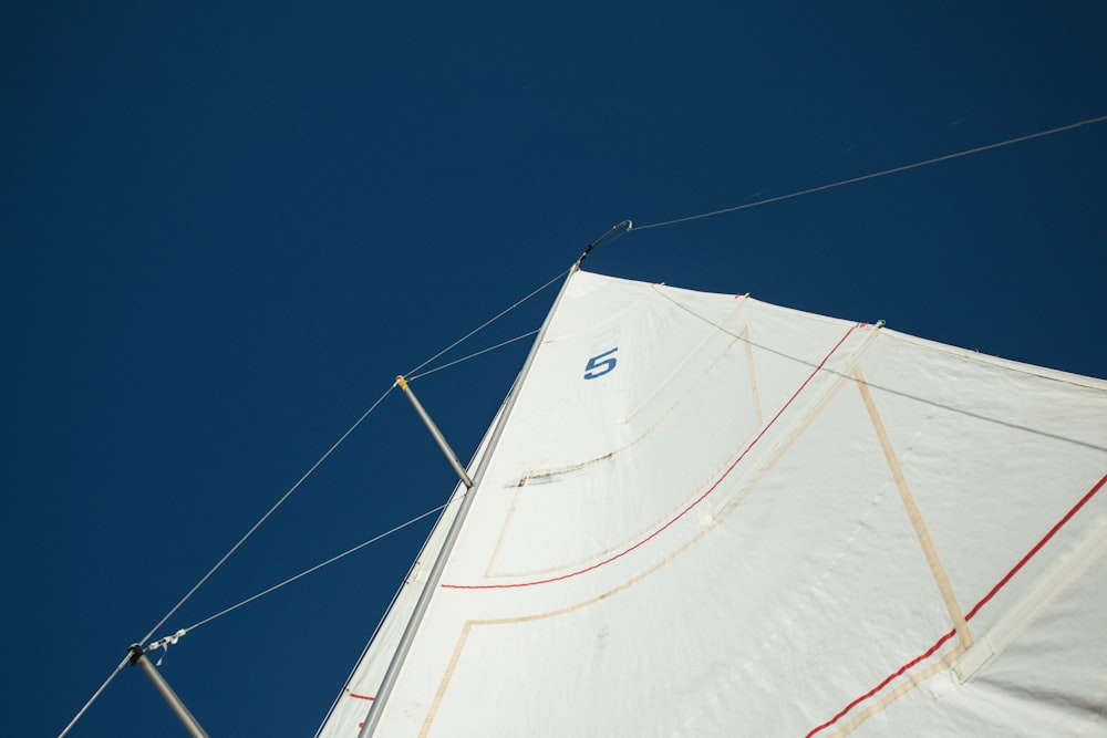 a white sail boat with a blue sky in the background