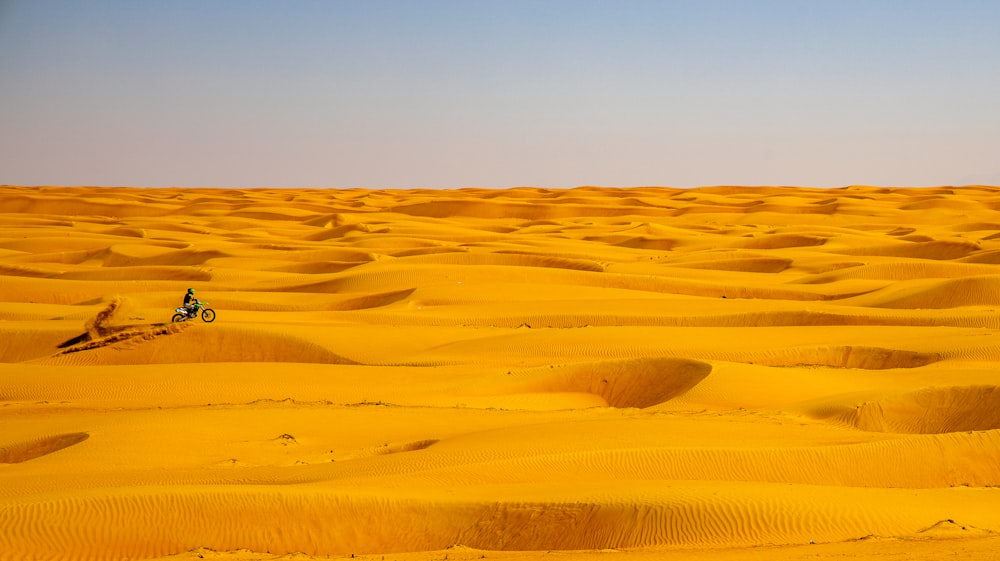 a person riding a bike in the middle of a desert