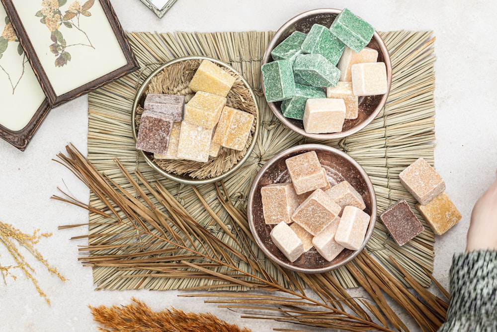 a table topped with bowls filled with different types of marshmallows