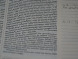 A close-up of a book or bible page showing printed text on the left side. The text is about a religious or historical topic, mentioning leaders and events. Handwritten notes can be seen on the lined section to the right, indicating engagement with the text.