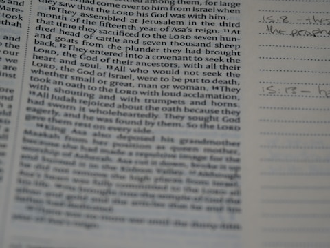 A close-up of a book or bible page showing printed text on the left side. The text is about a religious or historical topic, mentioning leaders and events. Handwritten notes can be seen on the lined section to the right, indicating engagement with the text.