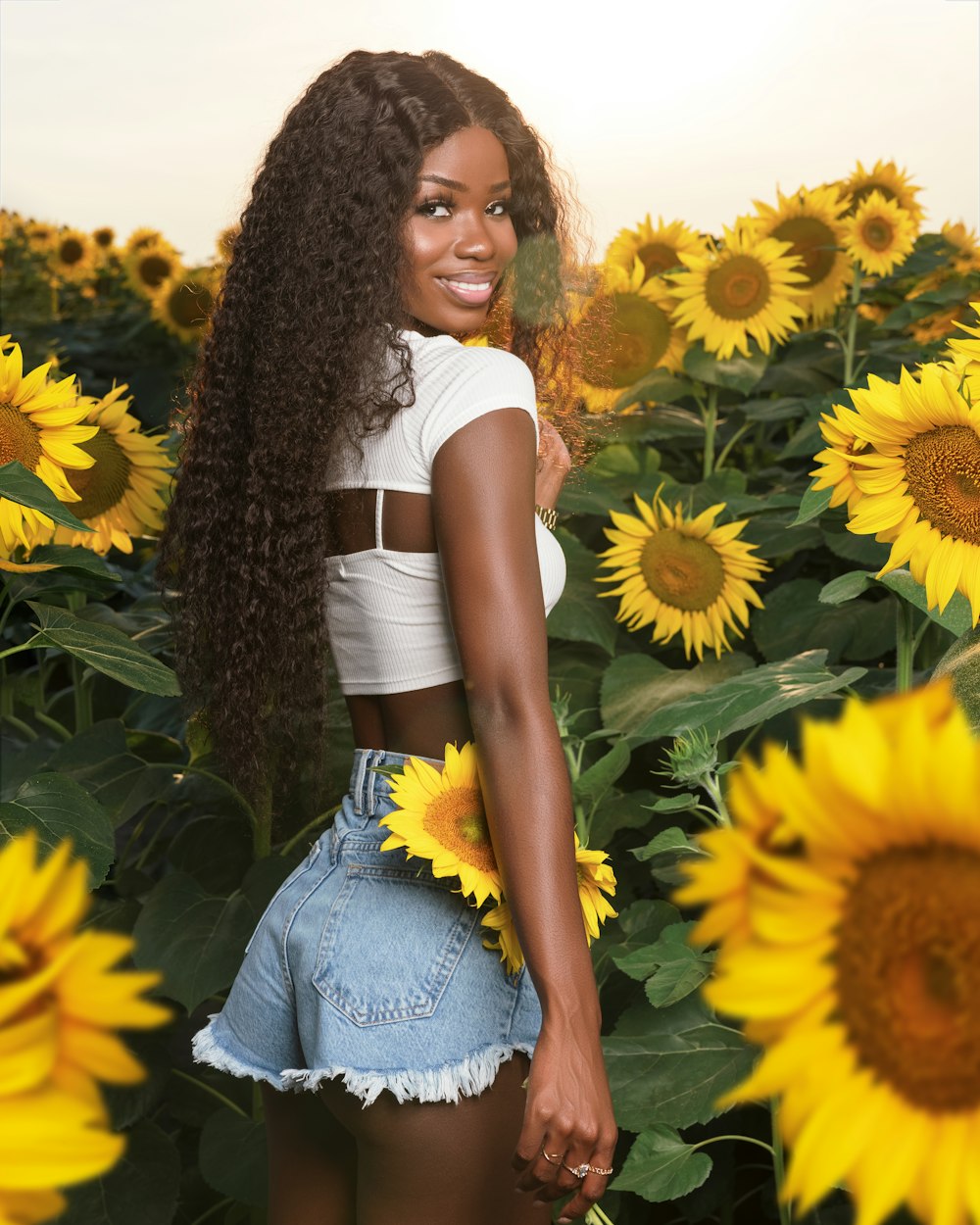 a woman standing in a field of sunflowers