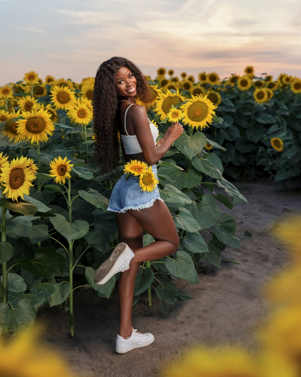 a woman standing in a field of sunflowers