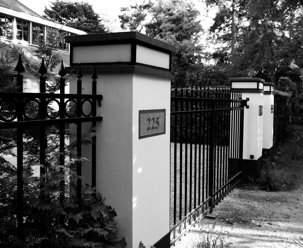 a black and white photo of a mailbox and fence