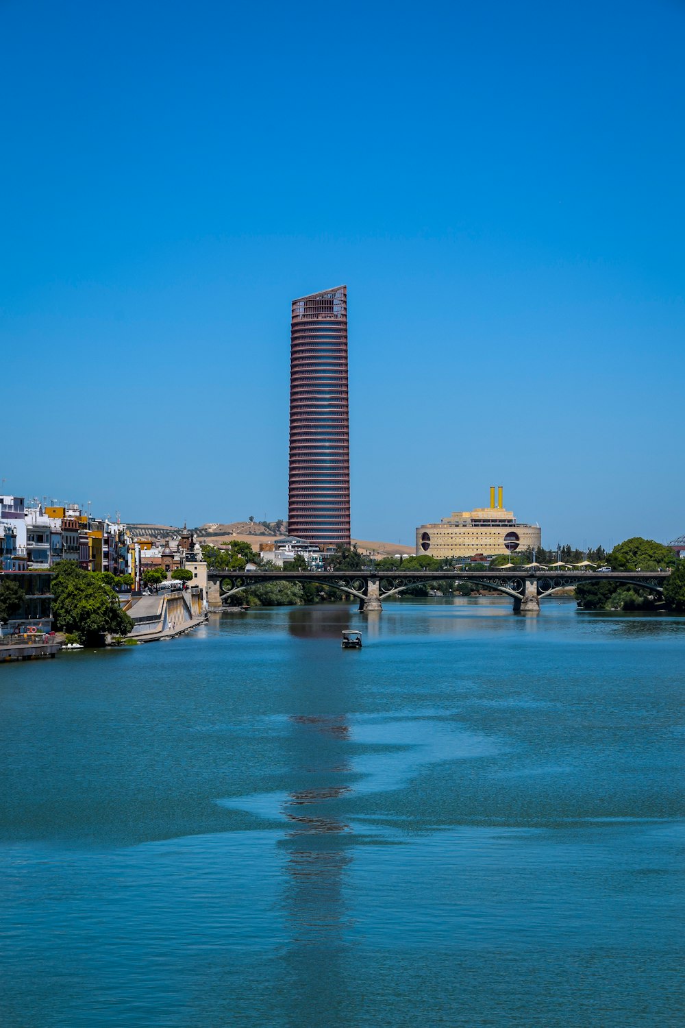 un cuerpo de agua con un puente y edificios al fondo