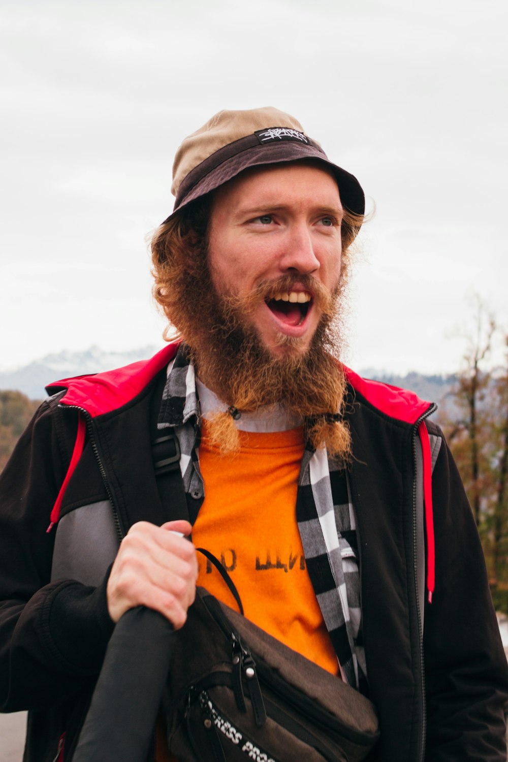 a man with a beard wearing a hat and jacket