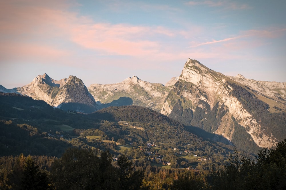 a view of a mountain range with trees in the foreground