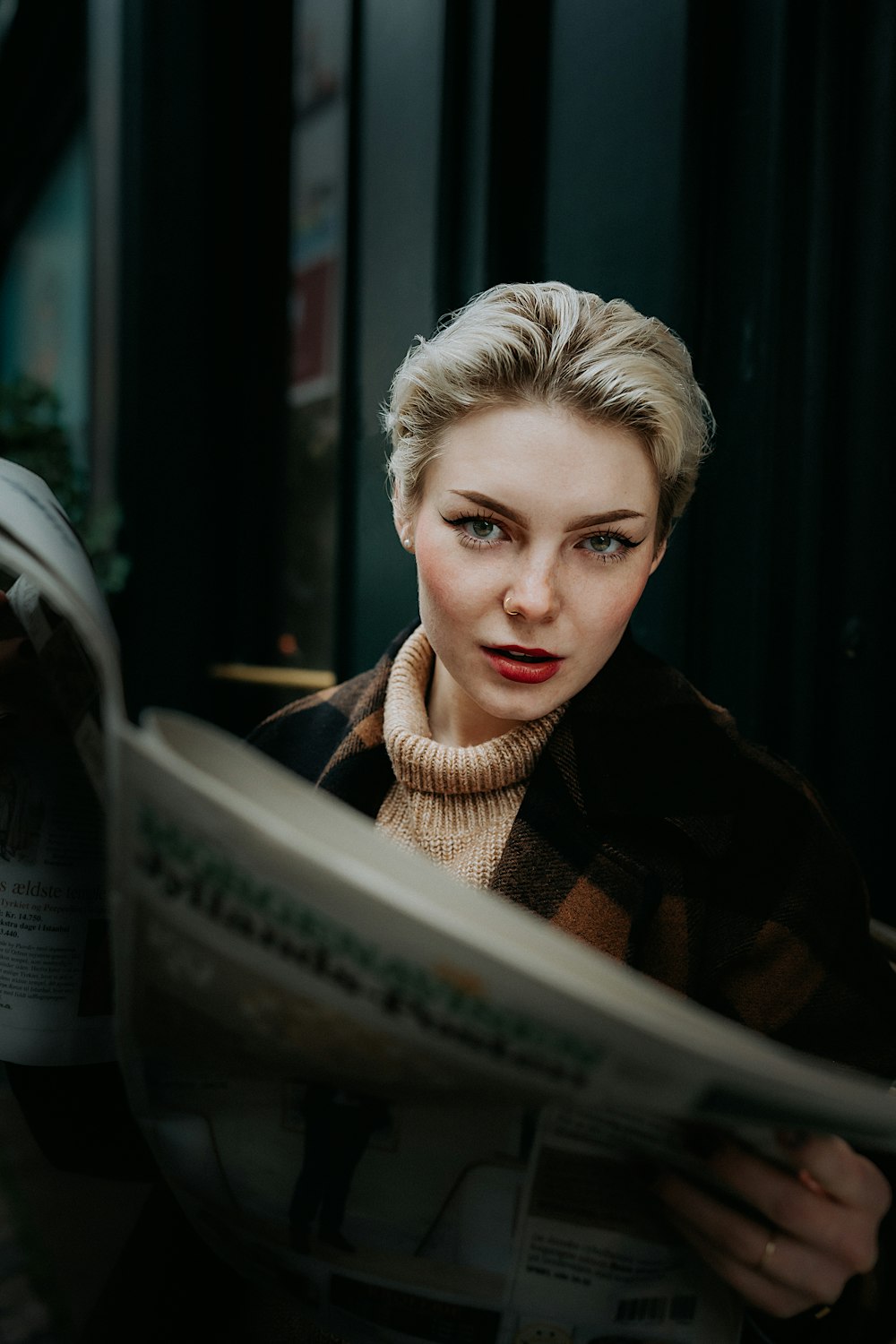 a woman is reading a newspaper outside