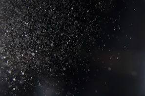 Microscopic view of air particles swirling, capturing the invisible conditions that affect health.