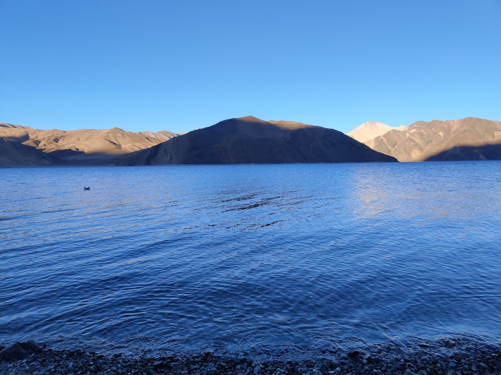 a body of water with mountains in the background