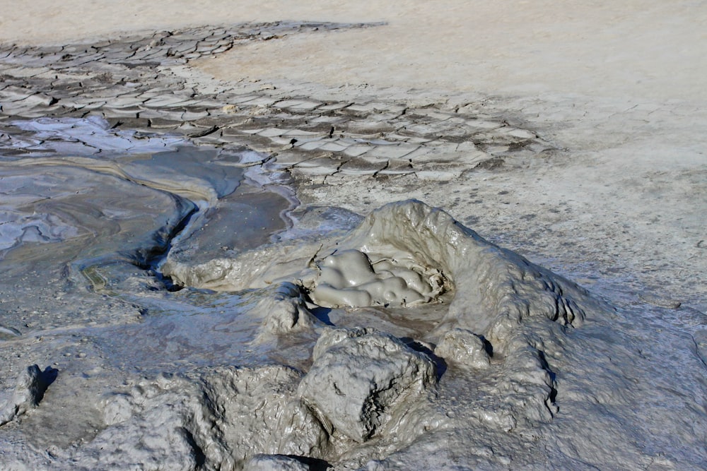 a rock formation in the middle of a muddy area