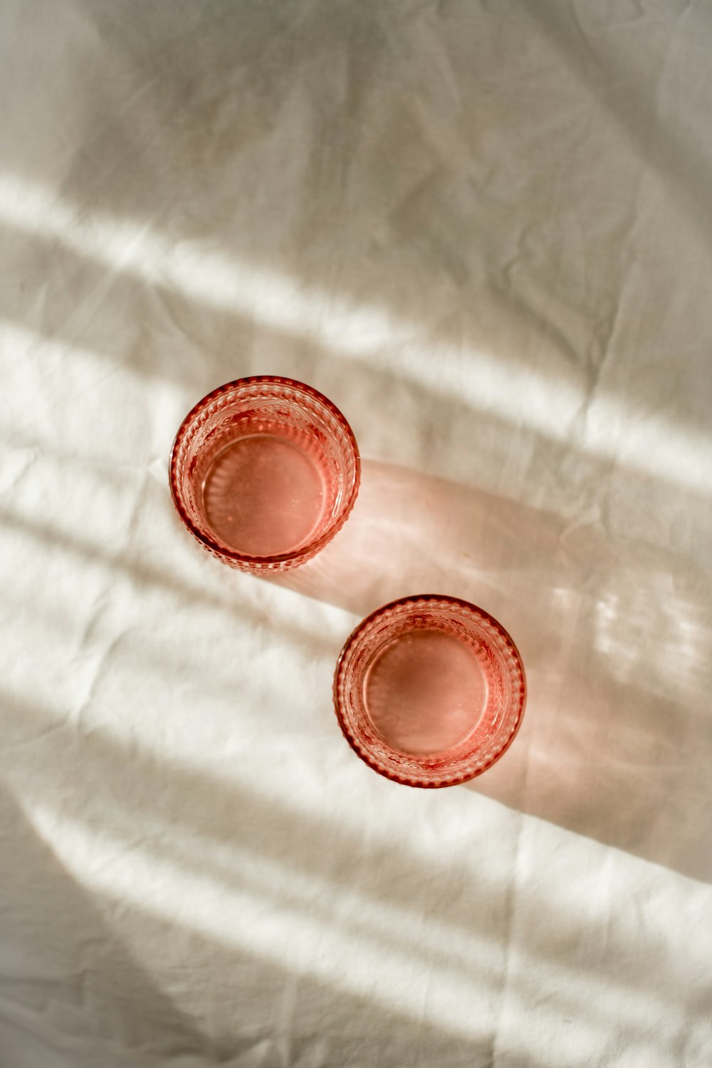 two red cups sitting on top of a white sheet