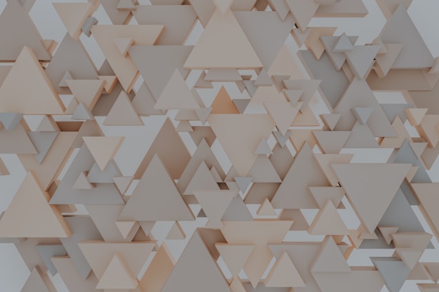 A pattern consisting of various overlapping and layered triangles in shades of beige and gray, creating a three-dimensional geometric effect.