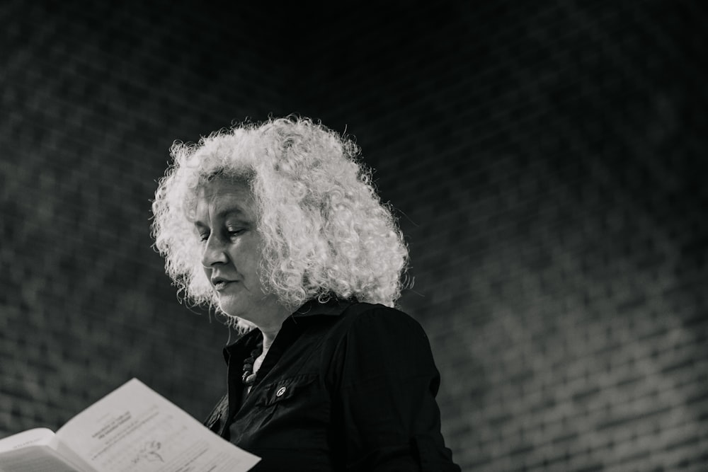 a woman with curly hair reading a book