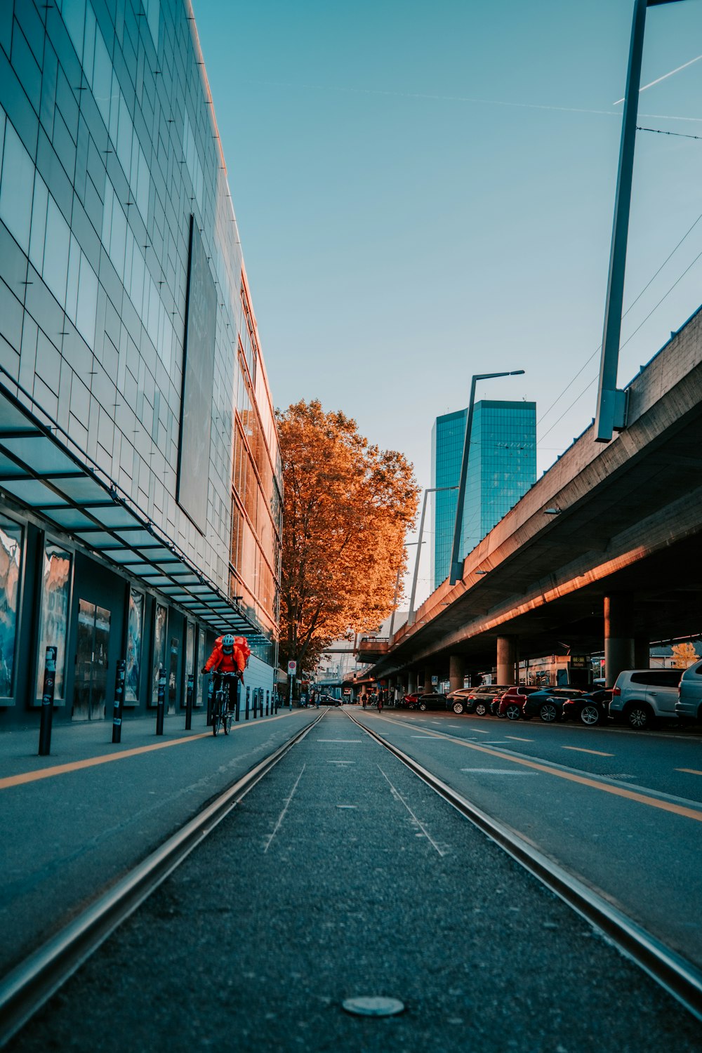 a person walking down a street next to a tall building