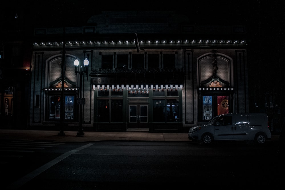 a car parked in front of a building at night