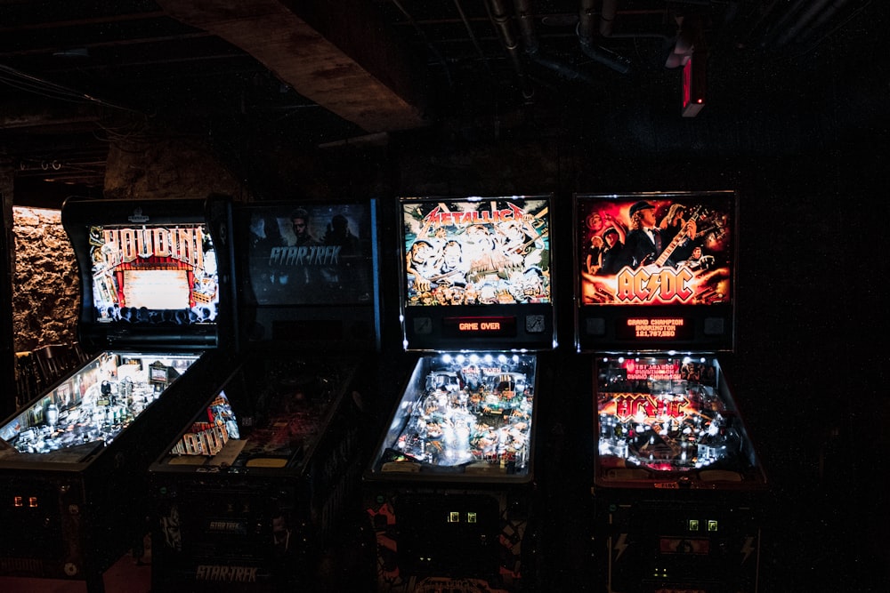 a row of pinball machines in a dark room