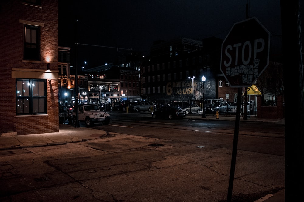 a stop sign on a city street at night