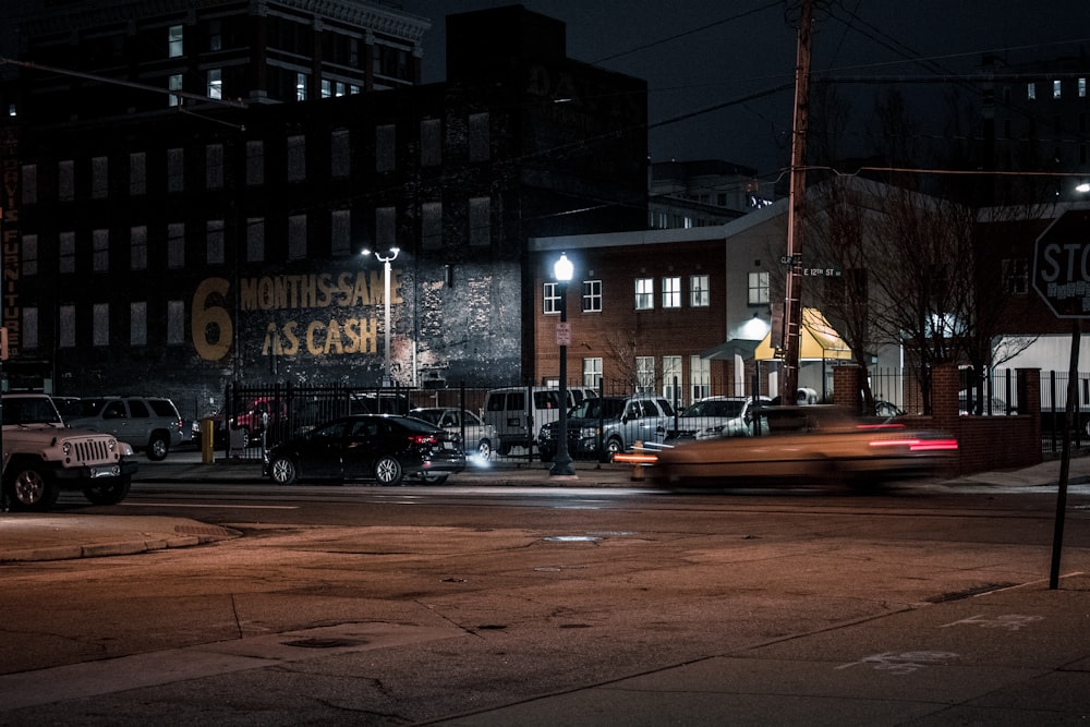 a city street at night with cars and buildings