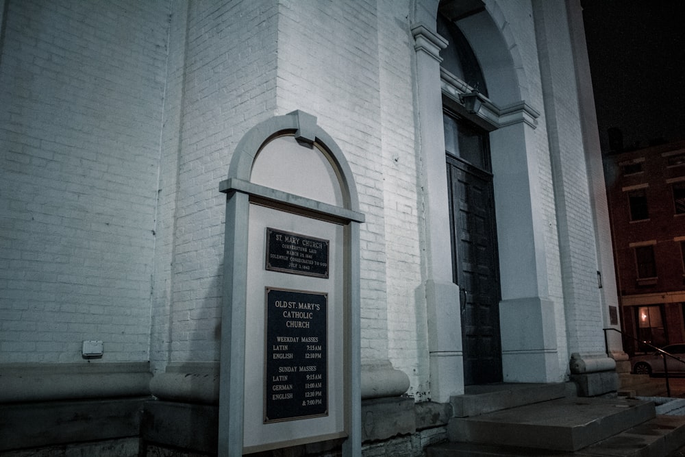 a white brick building with a plaque in front of it