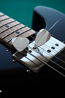 a close up of a guitar pick on a black guitar