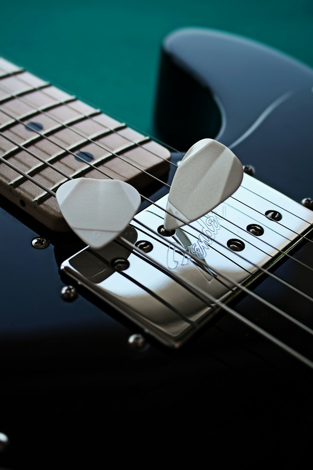 a close up of a guitar pick on a black guitar