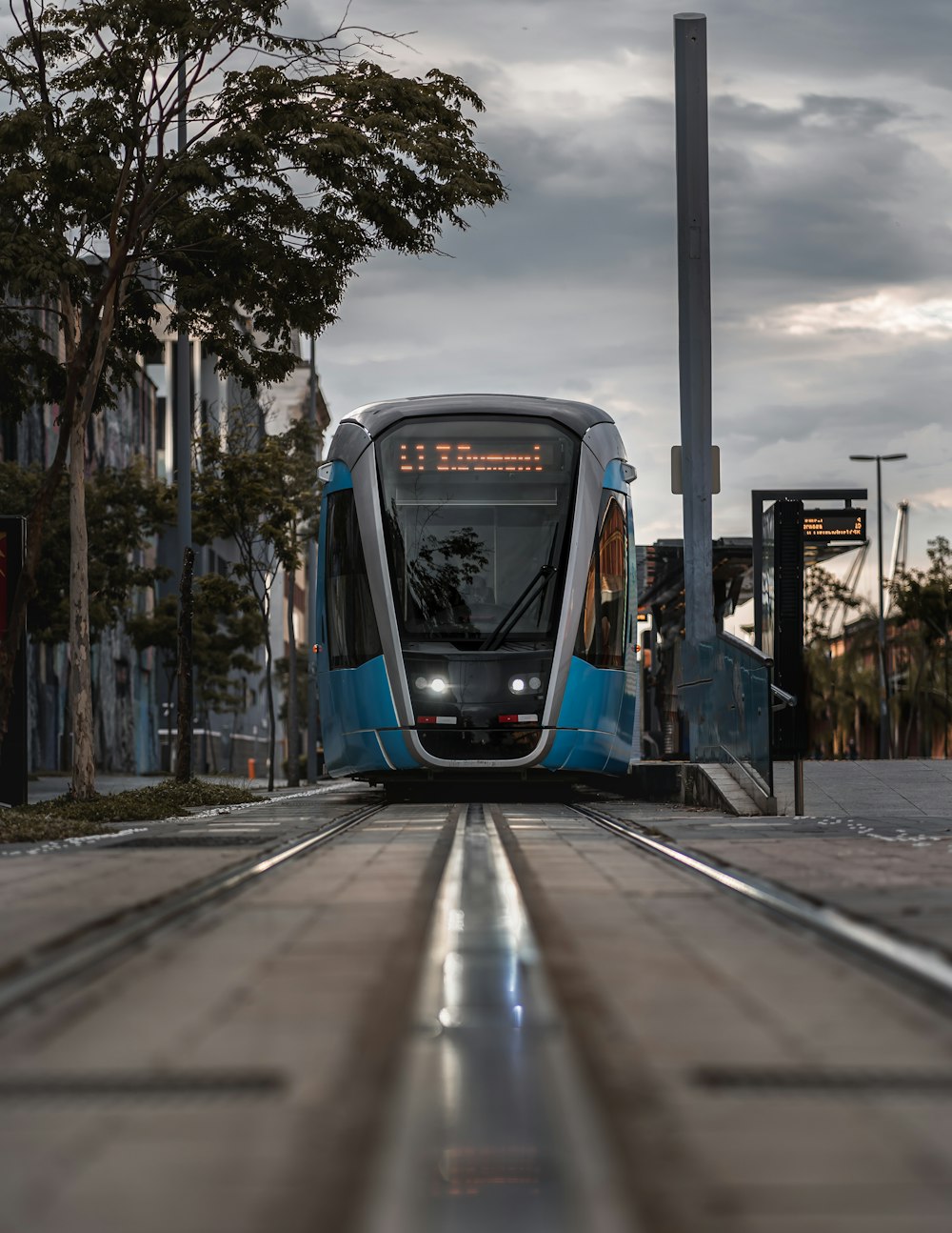 a blue and white train traveling down train tracks