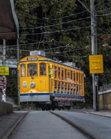 a yellow and blue trolley car traveling down a street