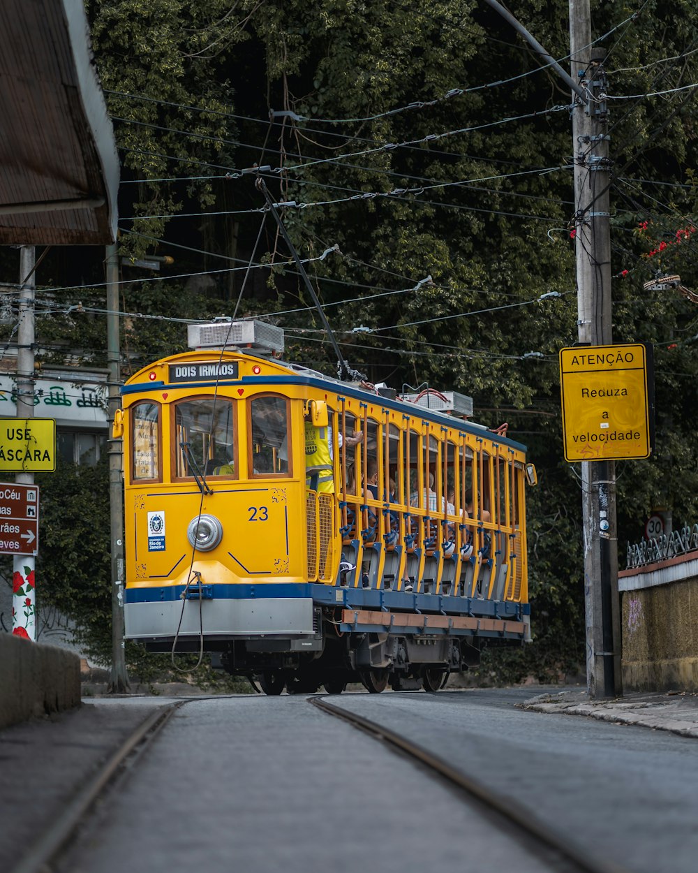 a yellow and blue trolley car traveling down a street