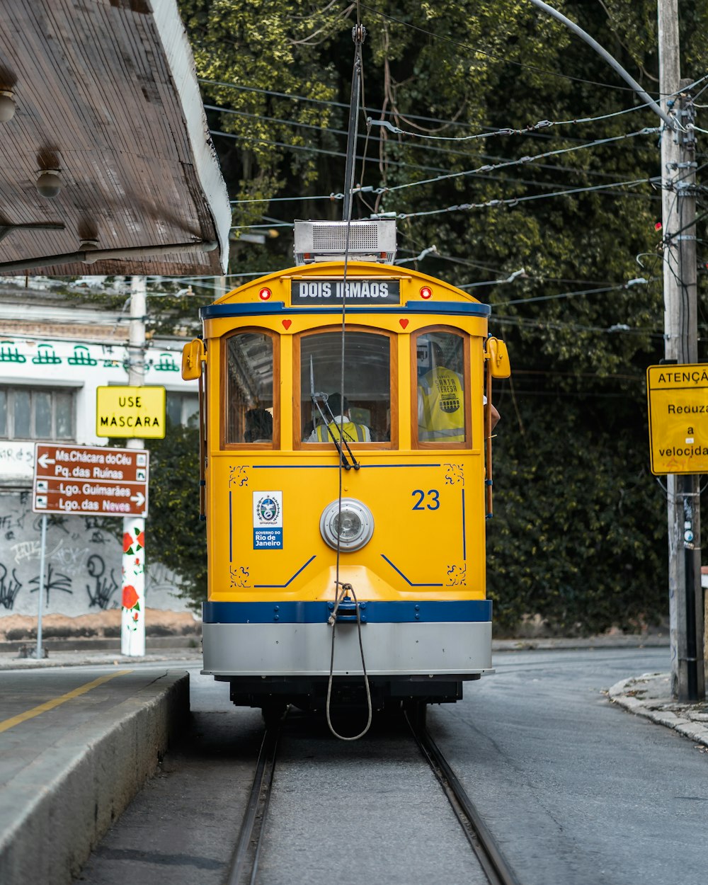 Ein gelber und blauer Zug, der die Bahngleise hinunterfährt