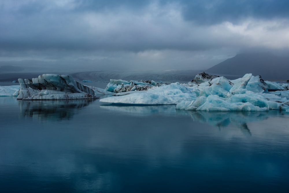 a group of icebergs floating on top of a body of water