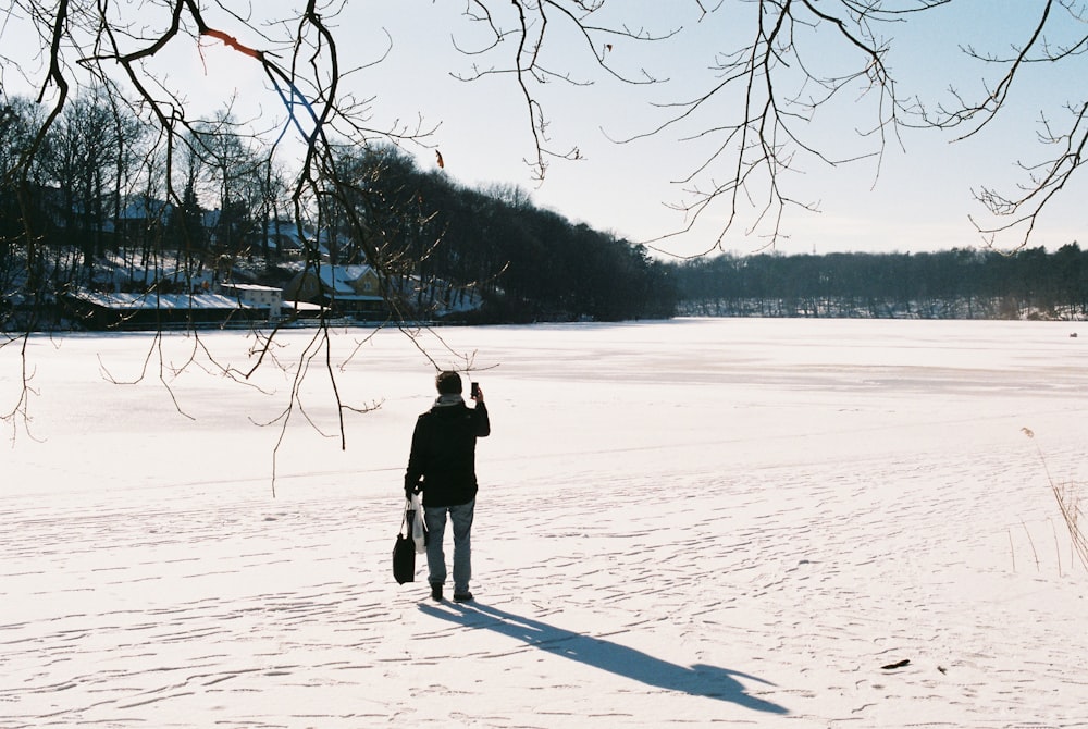 a man walking across a snow covered field