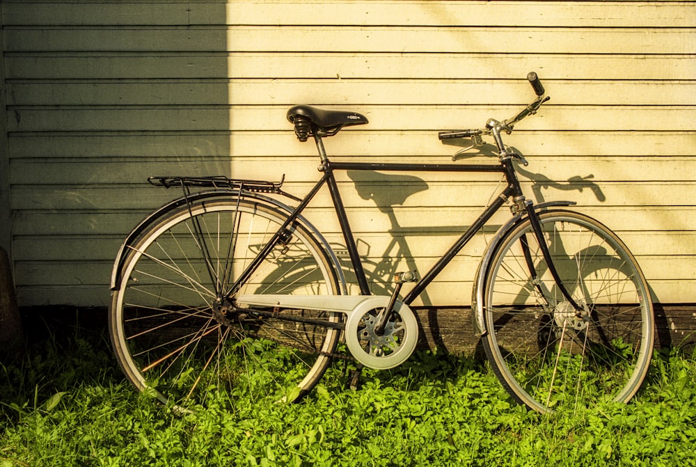 a bike parked next to a building in the grass