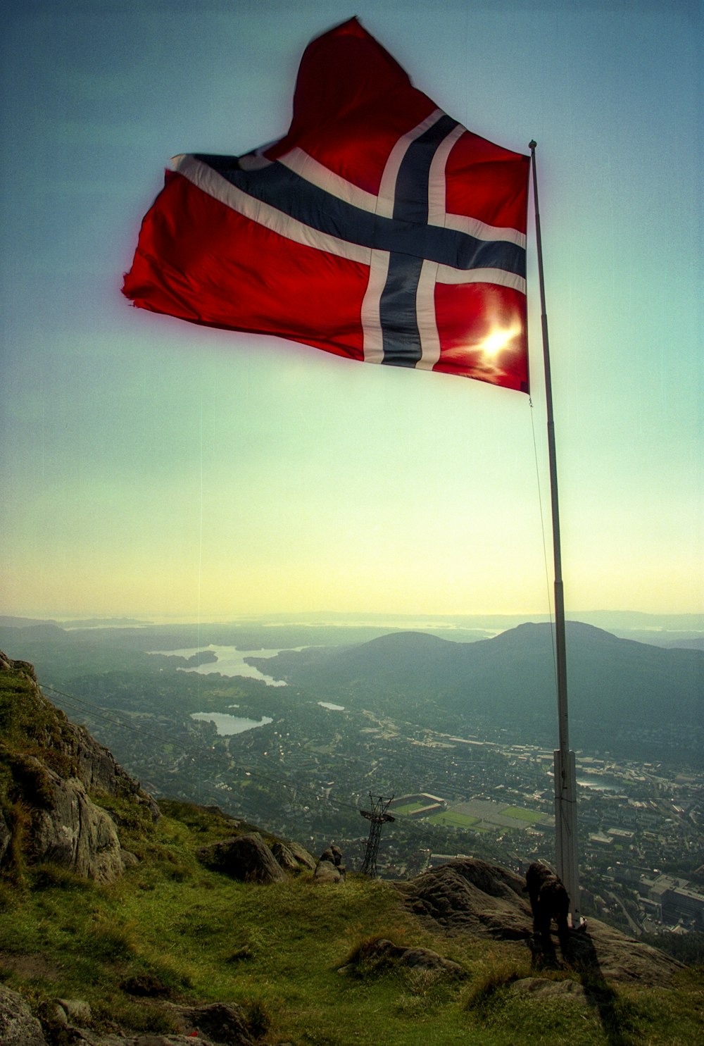 a flag on top of a hill with a sky background