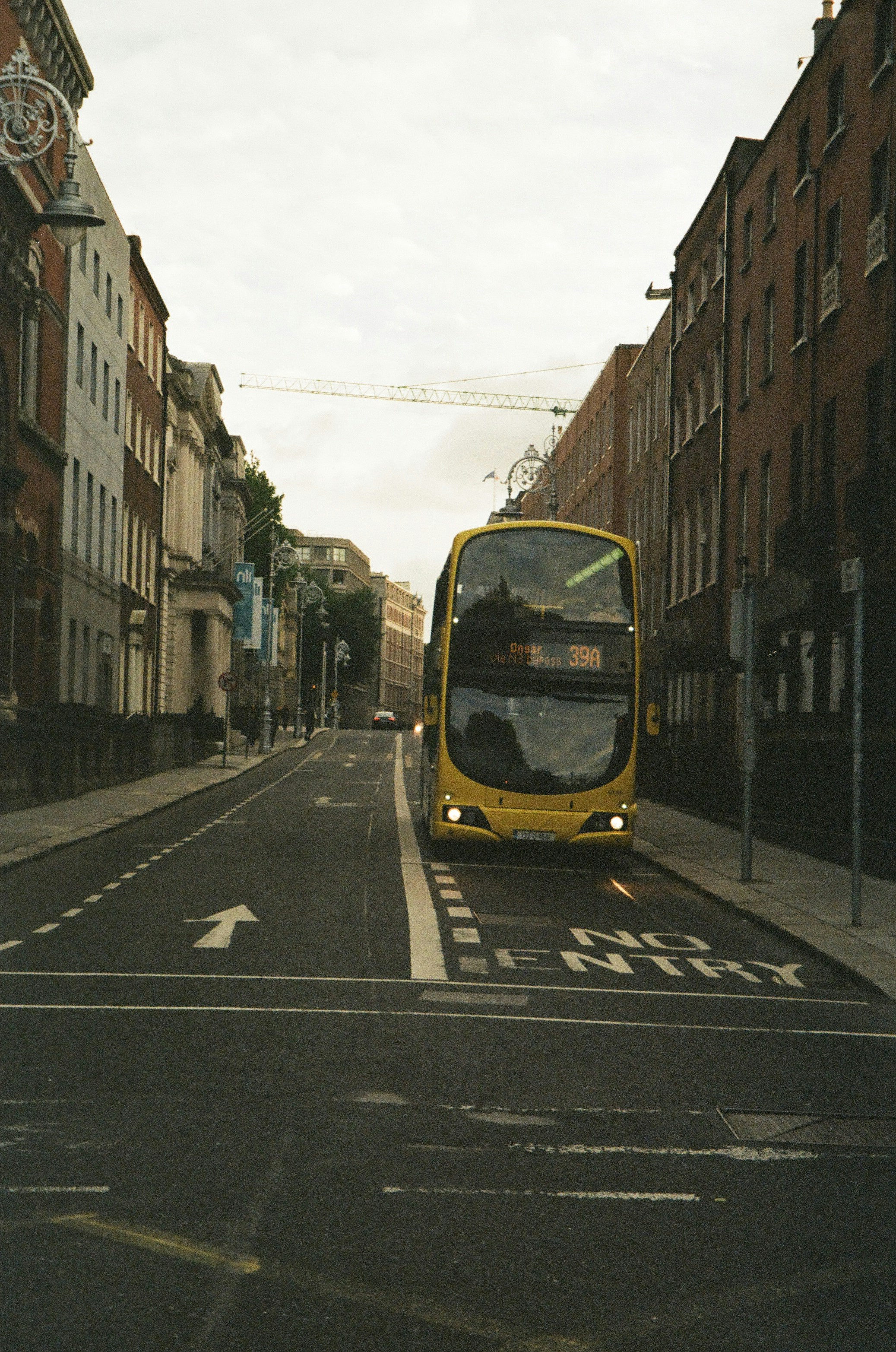 a yellow double decker bus driving down a street