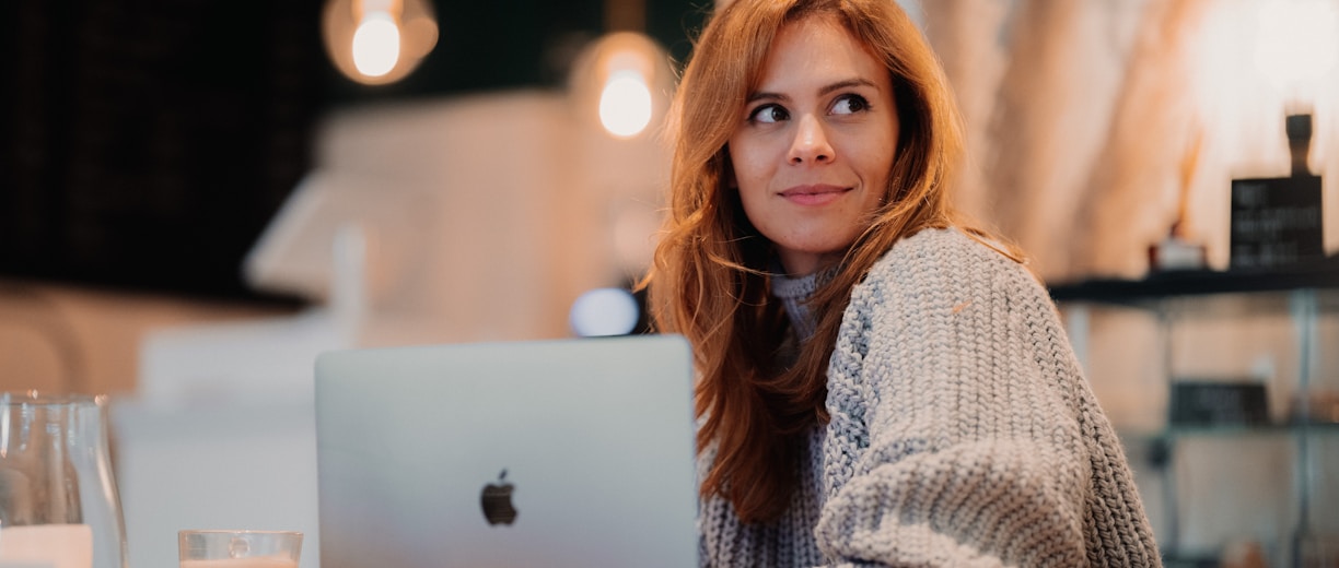 a woman sitting in front of a laptop computer