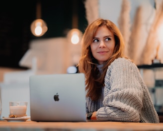 a woman sitting in front of a laptop computer