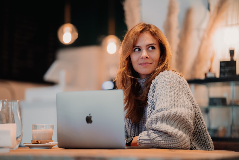 a woman sitting in front of a laptop computer