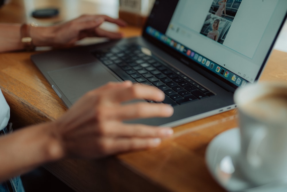 a person using a laptop on a wooden table