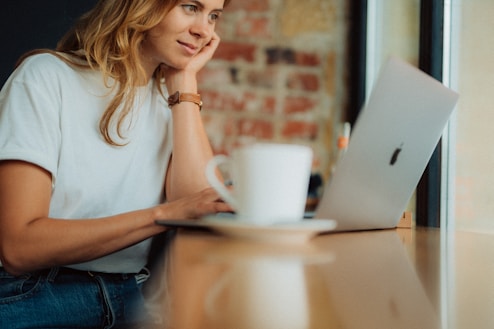 a woman sitting at a table with a laptop