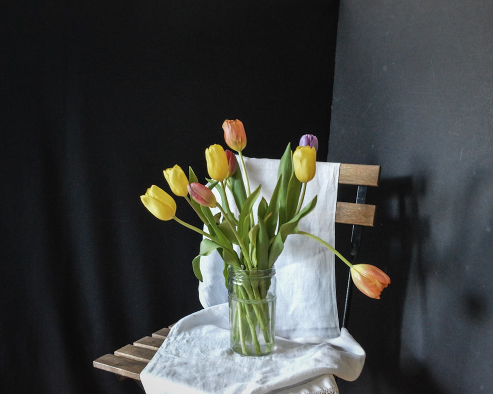 a vase of tulips sits on a napkin holder