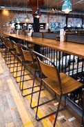 a row of wooden chairs sitting next to a bar