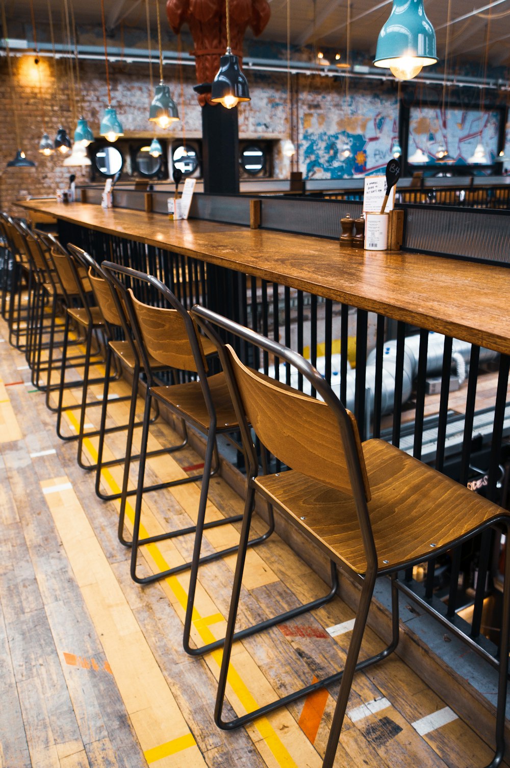 a row of wooden chairs sitting next to a bar