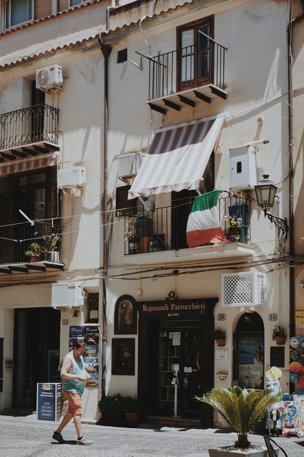 a woman walking down a street past a tall building