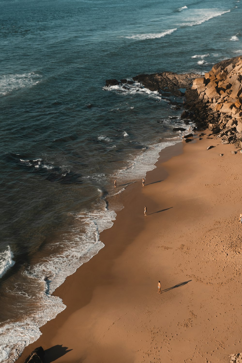 a group of people standing on top of a sandy beach