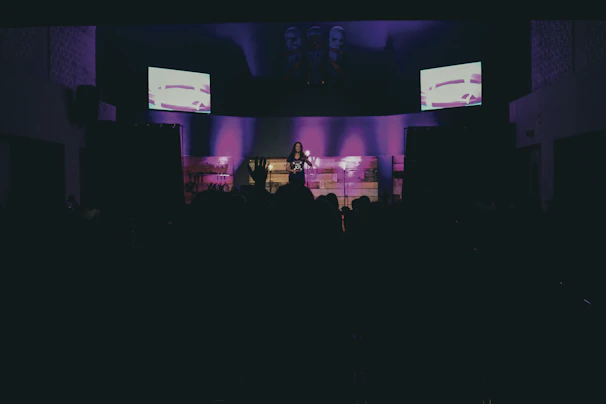 An audience captivated by a dark, luxurious immersive experience with glowing purple visuals.